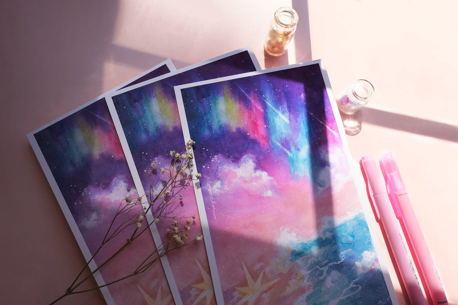 photo showcases a high quality art print of an original ink and watercolour ocean sky painting by moonchu. the illustration is very colourful with aurora and stars falling upon an ocean tide. a large, glowing star has fallen upon the beach. or washed ashore. up to you. sky gradients from purple to pink to light orange. a pretty dreamy art piece.