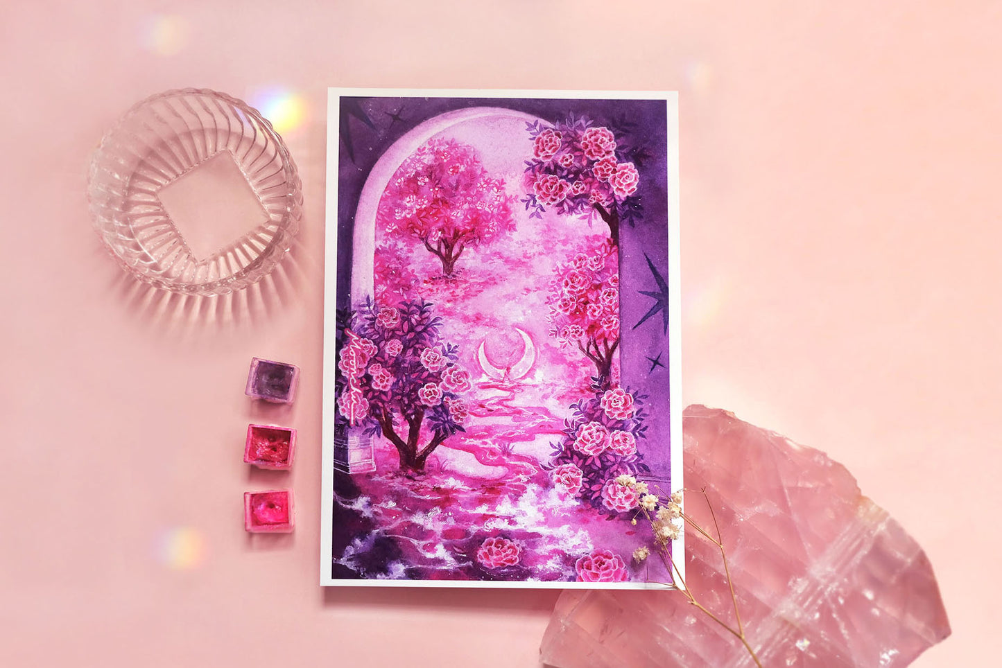richly vibrant original art print by moonchu illustrating an archway witnessing a crescent moon resting within a small creek in a garden of camellia trees. colours are of a red and pink and purple paint. purple tinkle stars decorate the archway as camellia flowers float down the foamy creek. a beautiful high quality art print for a garden lover or flower appreciator.