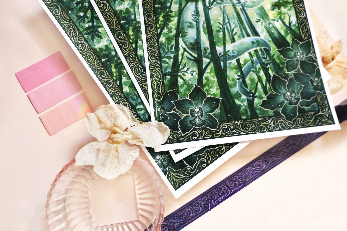 original mixed media art painting by moonchu depicting a lush, verdant snake winding through tall tree trunks. has an elaborate border with intricate dark green orchids framing the lower left and right. lunar new year art for growth inspiration, or if you are a snake lover or botanical friend. very green aesthetic, wooded forest illustration.