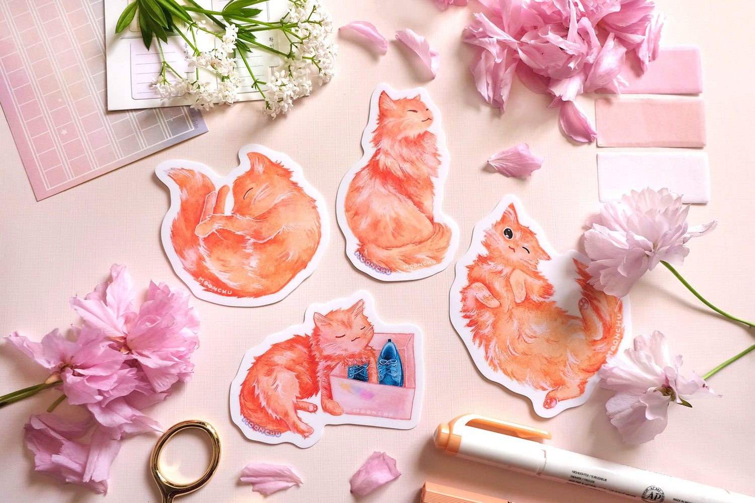 entire set of four original art cat stickers by moonchu! the vibrant high quality vinyl stickers are depicting cute cats in various poses, illustrated in watercolors. we have a cat curled up like a donut sleeping, a very regal kitty sitting up, very fluffy, a kitty admiring some blue shoes in a shoebox because my cat loves shoes, and a funny cat winking on his back. all very fluffy, very orange cats, very cute. other stationery items are in the photo, perfect for any sticker lover or cat lover.