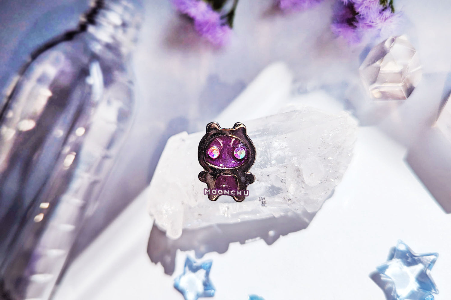 photo depicts moonchu's original art enamel pin. this space galaxy alien pin features two prismatic rainbow crystals for eyes, and a metallic sparkly magenta enamel paint. alternative pin features metallic sparkly teal paint. a very unique enamel pin.